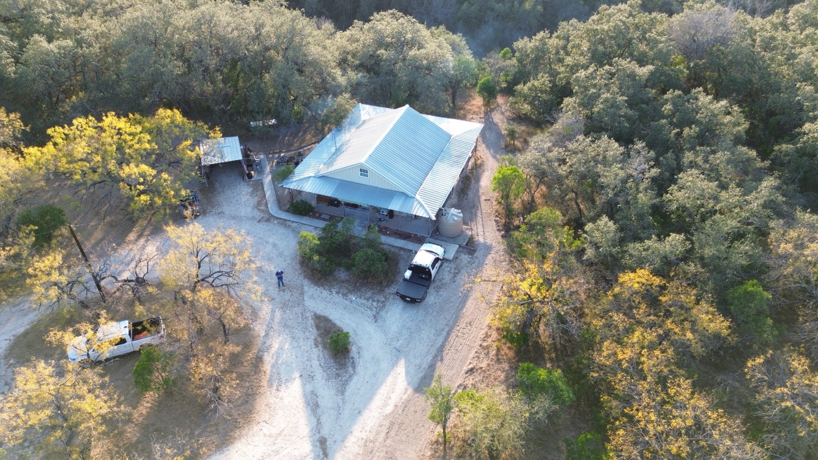 Custom home with a metal roof in the North Texas countryside, aerial view